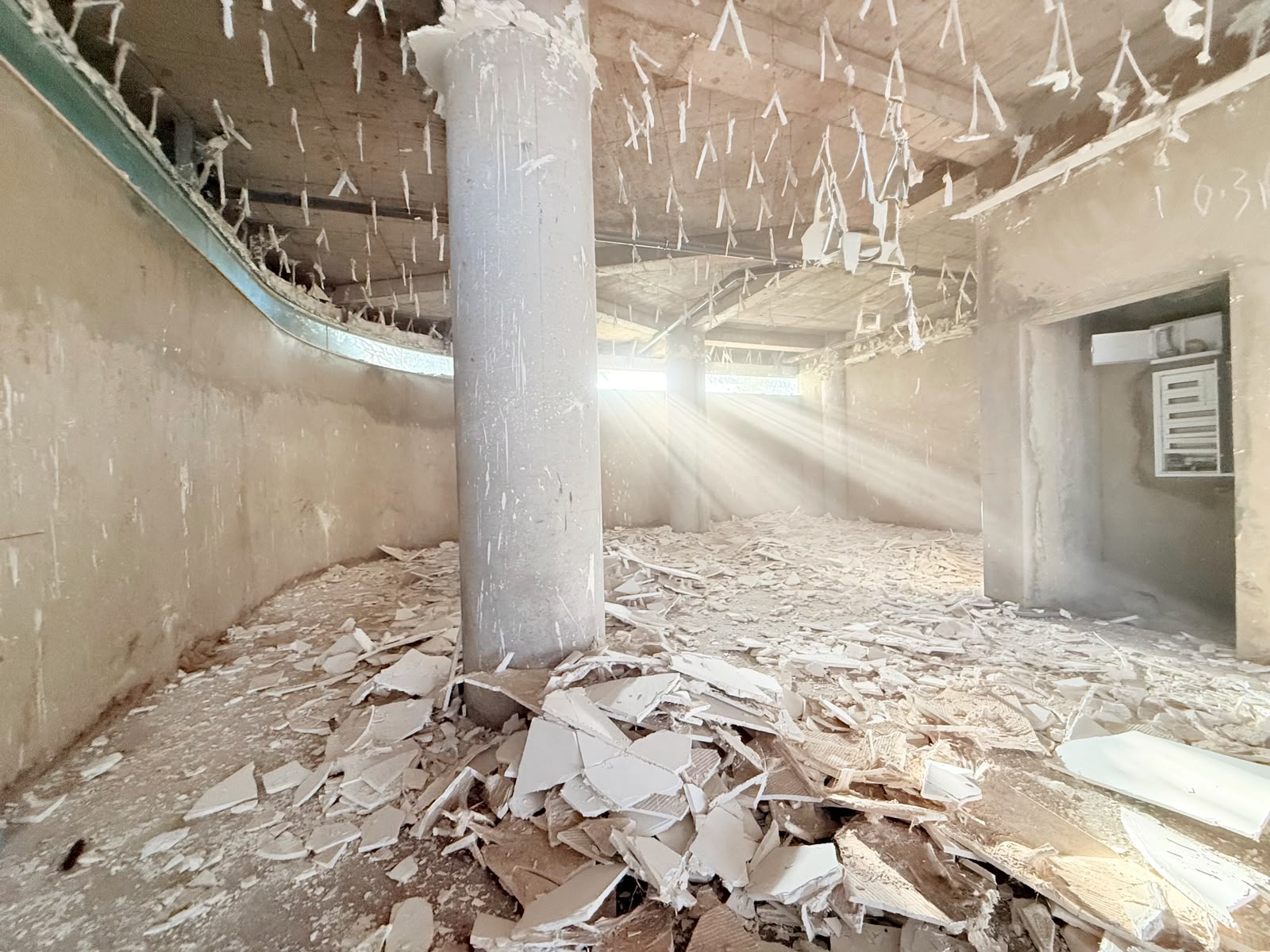 Colonne et gravats sous les rais de lumière, plafonds déposés